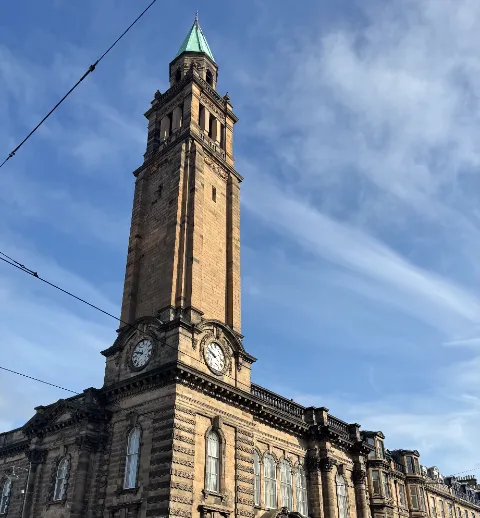 Stone clock tower against a blue Edinburgh sky