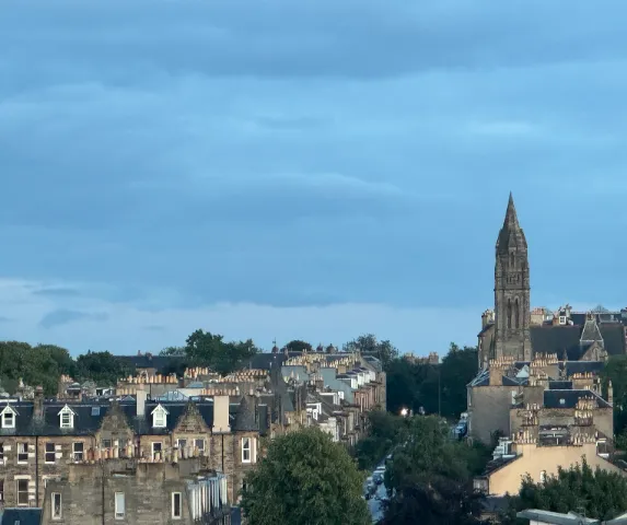 Edinburgh rooftops and a church spire at dusk