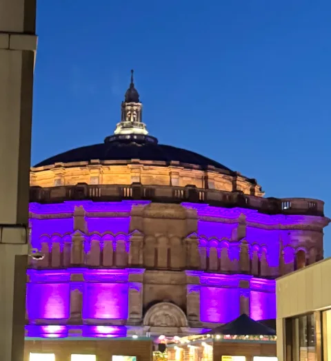 McEwan Hall dome lit purple against the evening sky
