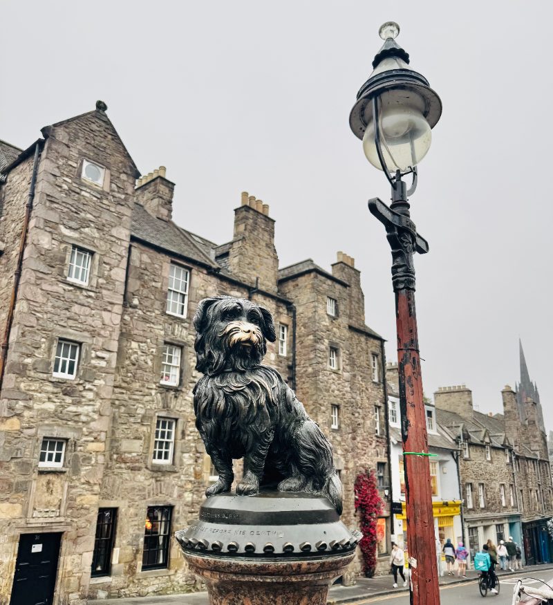 The Greyfriars Bobby statue beside a lamp post on a misty day